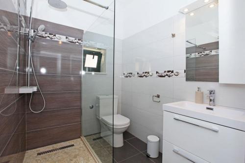 a bathroom with a toilet and a glass shower at Family friendly house with a swimming pool Bol, Brac - 23787 in Bol
