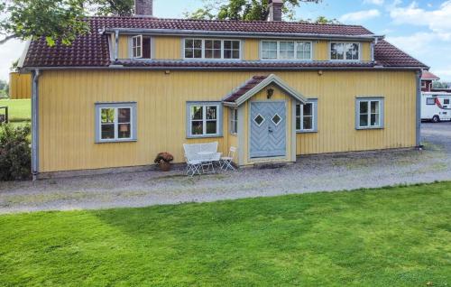 a yellow house with a blue door at 4 Bedroom Awesome Home In Jönköping in Jönköping