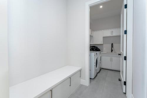 a kitchen with white cabinets and a washer and dryer at Waterfront Home with Pool Spacious Bay , Sleeps 16 in Port Isabel