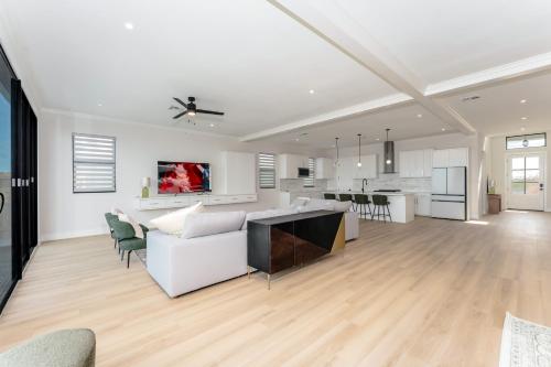 a living room and kitchen with white walls and wood floors at Waterfront Home with Pool Spacious Bay , Sleeps 16 in Port Isabel