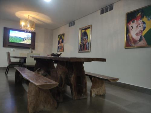 a room with a wooden table and two benches at Pousada Café Villa Monnaié in Chapada dos Guimarães