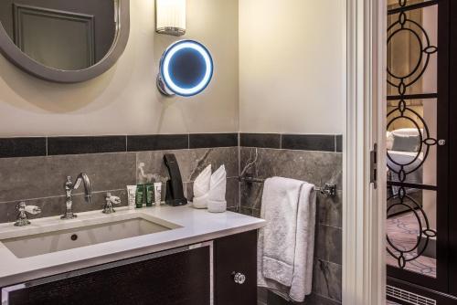 a bathroom with a sink and a mirror at Courthouse Hotel Shoreditch in London