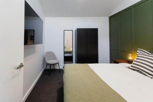 a bedroom with a large bed and a chair at Yarra Valley Grand in Yarra Glen