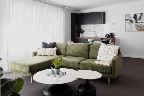 a living room with a green couch and a table at Yarra Valley Grand in Yarra Glen