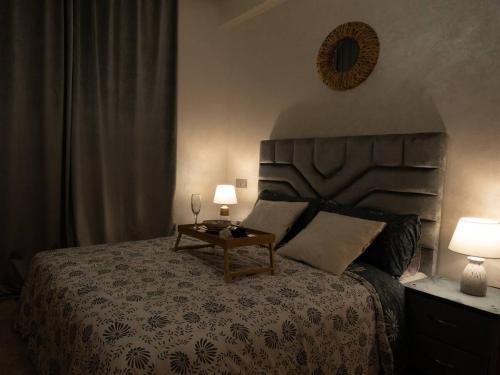 a bedroom with a bed with a table and two lamps at Nice & Comfortable 2BHK panoramic balcony with swimming pool in Aïn Harrouda