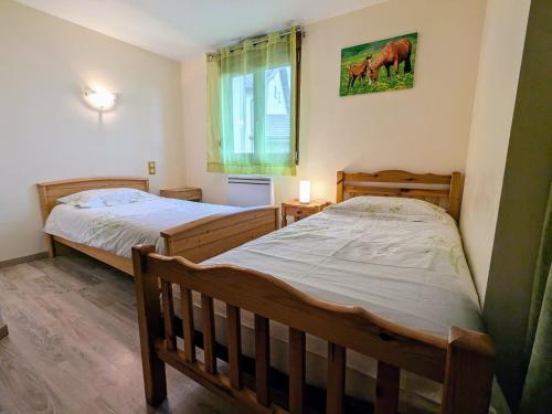 a bedroom with two beds and a window at Charmante maison rénovée avec 3 chambres, garage, et animaux admis à Gerbamont - FR-1-589-161 in Gerbamont 