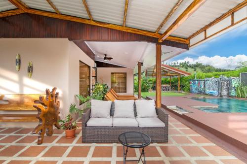 an outdoor patio with a couch and a pool at Casa Oasis La Fortuna Private Pool AC & WiFi 100 mbps in San Francisco