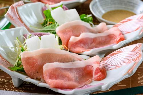 a plate of meat and cheese on a table at Senkeien Tsukioka Hotel in Kaminoyama