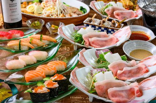 a table topped with plates of sushi and other foods at Senkeien Tsukioka Hotel in Kaminoyama