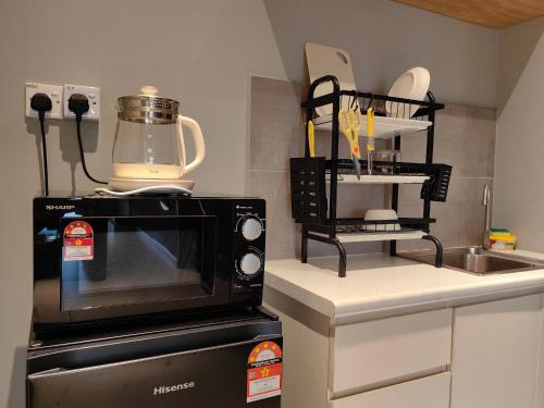 a kitchen with a microwave oven and a sink at Near Airport K Avenue Family Room in Donggongon