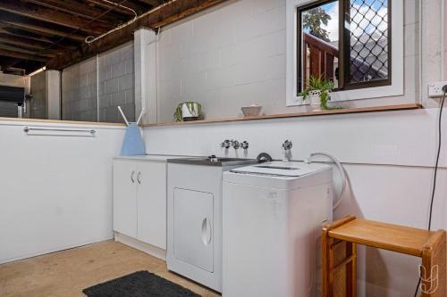 eine Küche mit Spüle und Waschmaschine in der Unterkunft 3 Bedroom Family-Friendly Coastal Haven! in Yeppoon