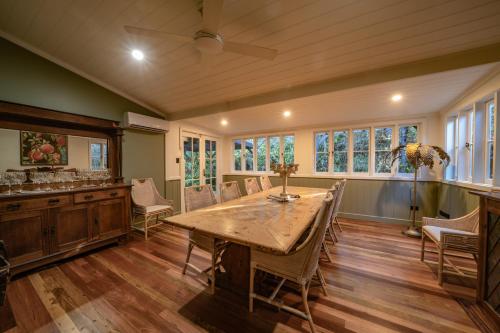 a large dining room with a wooden table and chairs at The Rustic Nest Yarramalong in Yarramalong