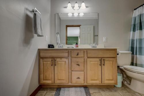 ein Badezimmer mit Waschbecken, Toilette und Spiegel in der Unterkunft Locust Lake Livin Hot Tubfire Pitskiingpets in Pocono Lake