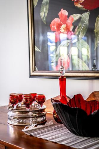 a table with wine glasses and a picture on it at The Rustic Nest Yarramalong in Yarramalong