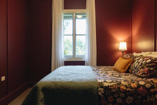 a bedroom with a bed and a window at The Rustic Nest Yarramalong in Yarramalong