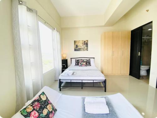 a bedroom with a bed and a large window at Cebu One Pavillion Place by P&J in Cebu City