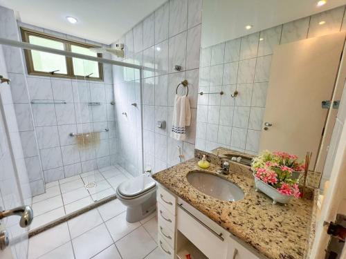 une salle de bain avec un lavabo, une douche et des toilettes dans l'établissement Apartamento de frente para o Mar, à Guarapari