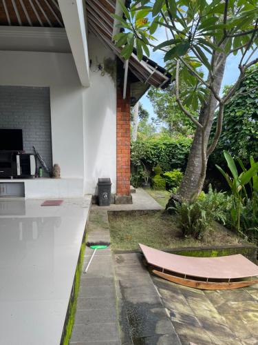 a house with a surfboard on the side of it at Pranajaya loka villa in Tejakula