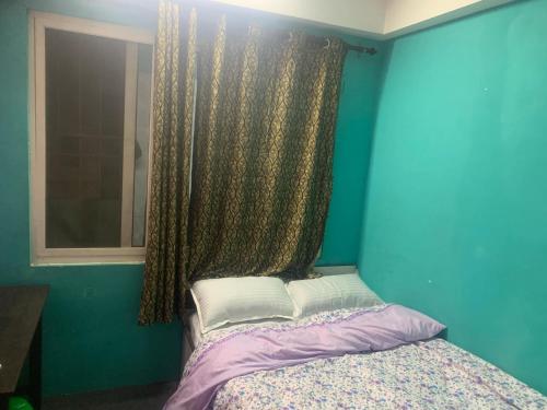 a blue room with a bed with a window at Swoyambhu Home Stay in Kathmandu