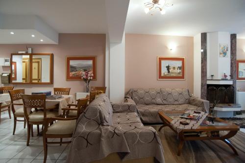 a living room with a couch and a table and chairs at Pitho in Delfoi