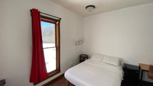 a small bedroom with a bed and a window at ITH San Diego Adventure Hostel in San Diego