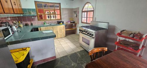 a kitchen with a stove and a table in it at MejorCadaDia Eco-Farm in Paso Ancho