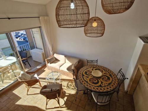 un salon avec une table et des chaises dans l'établissement Appart 3 pièces climatisé vue mer avec parking Sainte-Maxime - FR-1-780-89, à Sainte-Maxime