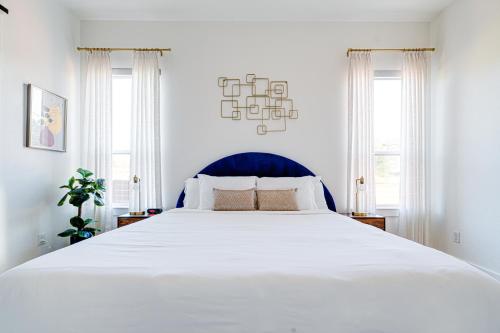 a large white bed in a white bedroom with windows at Urban Oasis with Top Houston Attractions nearby in Houston