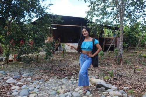 a woman standing on a pile of rocks at Cabaña Princesa de Agua in Tena