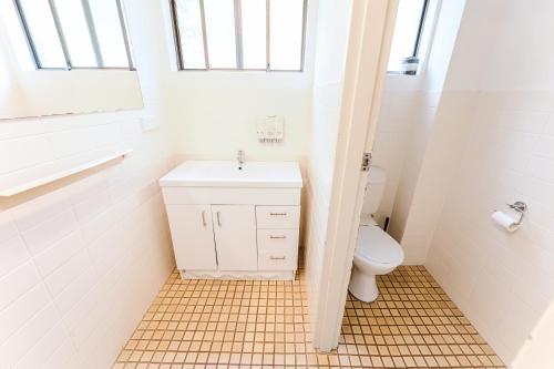 a bathroom with a sink and a toilet at Country 2 Coast Motor Inn Coffs Harbour in Coffs Harbour