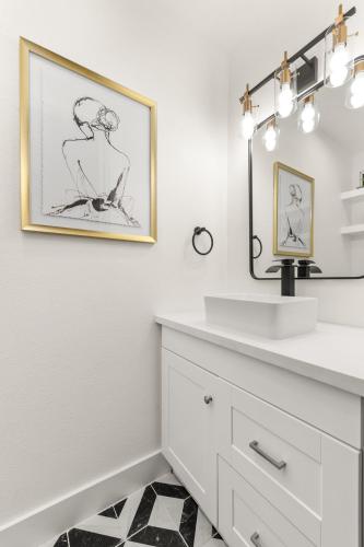 a white bathroom with a sink and a mirror at Urban Oasis with Top Houston Attractions nearby in Houston