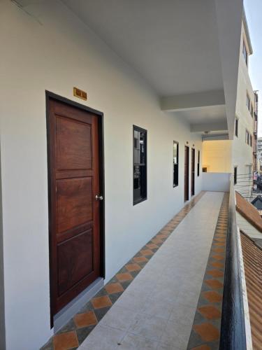 a hallway with a wooden door in a building at Middle tree house pattaya in Pattaya