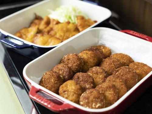 two trays filled with meatballs and other food items at Hotel Wing International Miyakonojo in Miyakonozyō