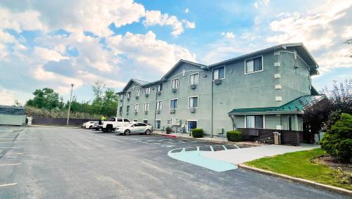 a large building with cars parked in a parking lot at Magnuson Hotel Fort Wayne North - Coliseum in Fort Wayne