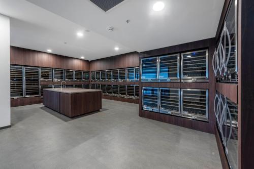 a large wine cellar with wooden cabinets and a large table in the middle at High Society Apartment Belconnen in Belconnen