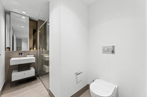 a bathroom with a toilet and a sink at Brand New 2BR Apt at Mel CBD in Melbourne