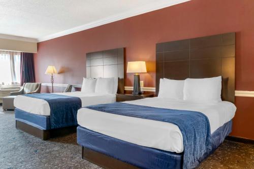 a hotel room with two beds and a couch at Best Western Greenfield Inn in Allen Park