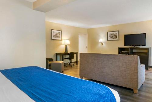 a hotel room with a bed and a flat screen tv at Best Western Greenfield Inn in Allen Park