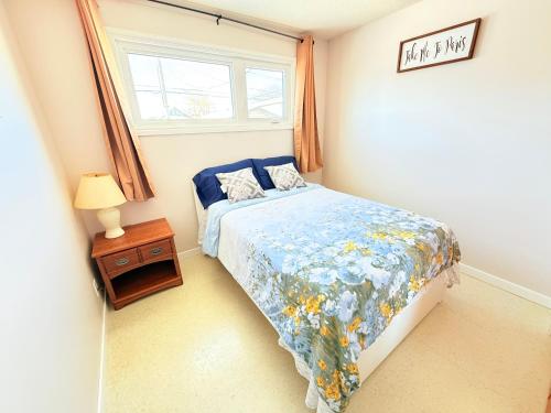 a small bedroom with a bed and a window at Cozy main floor, 03 Bedrooms, close to Downtown REGINA in Regina