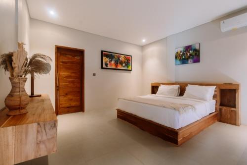 a bedroom with a bed and a vase on a table at Campbar 4 by AGATA in Canggu