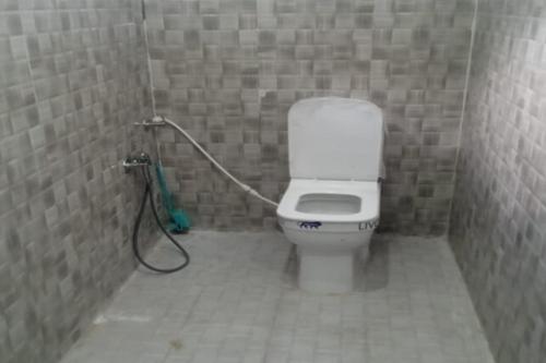 a bathroom with a toilet with a hose at Hotel Sarthak Bed n Breakfast by StayApart in Phata