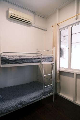 a room with two bunk beds and a window at Cutie House in Tawau