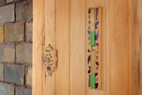 a wooden door with a remote control and a thermometer at Resident Hotel Almaty in Almaty