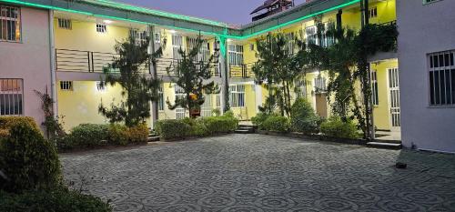 an empty courtyard of a building with trees and plants at Avi Guest House in Addis Ababa