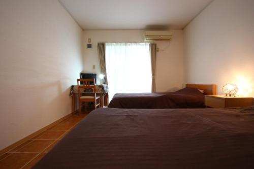 a hotel room with two beds and a window at AsobiBASE Yamabare-House in Ishigaki Island