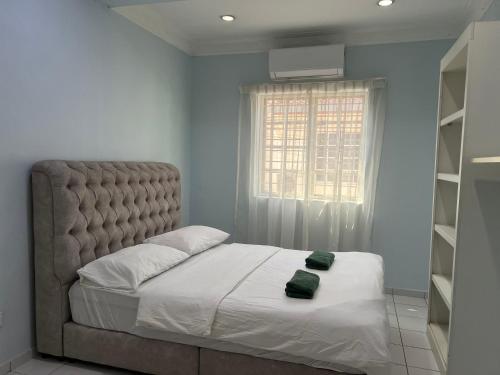 una camera da letto con un grande letto con lenzuola bianche e una finestra di Home in Bandar Baru Bangi a Bandar Baru Bangi
