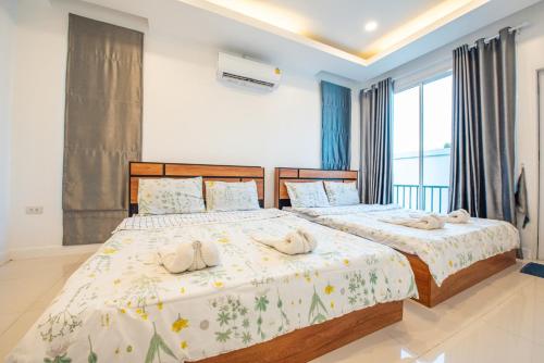 Un dormitorio con dos camas con toallas encima. en Garden House Na Jomtien, en Na Jomtien
