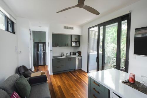a kitchen and living room with a ceiling fan at Bushland setting close to Sydney CBD- stand alone apartment in Sydney