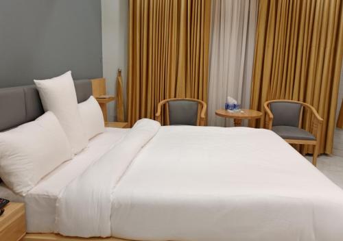 a large white bed in a hotel room at Leading Continental Hotel - Muzaffarabad AJK in Muzaffarabad