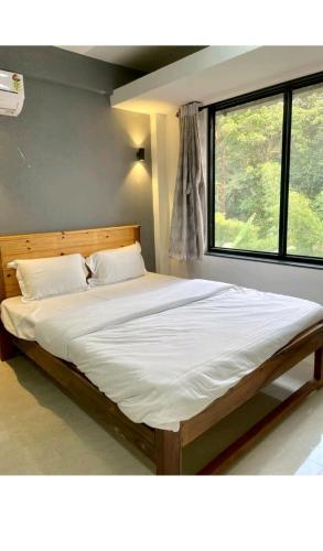 a large bed in a room with a large window at 1RK charming apartment-1 in Assagao